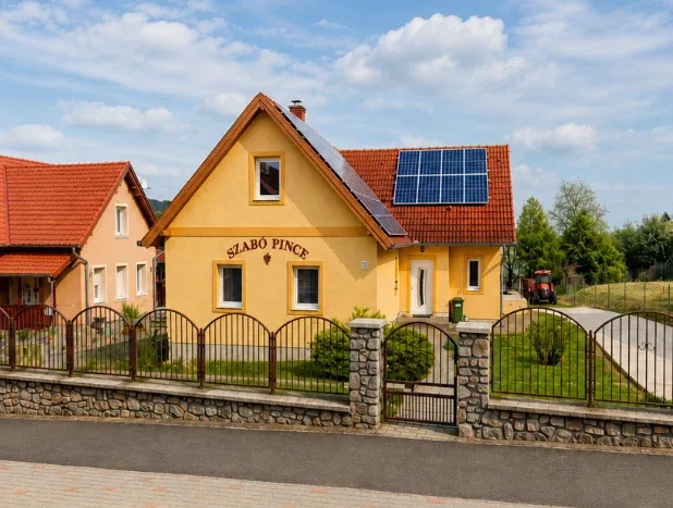 A Szabó Családi Pincészet háza, napelemekkel a tetőn, a Szabó Pince felirattal a homlokzaton